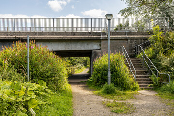 River Ayr Way footpath below beam and slab concrete road bridge with metal railings on A77 Ayr town...