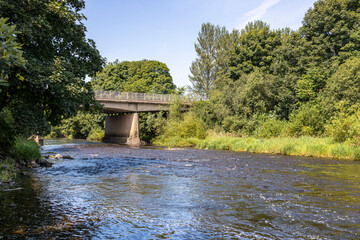 Beam and slab concrete road bridge with metal railings over River Ayr on A77 town bypass
