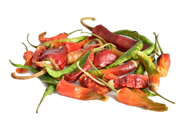 Hot chili peppers of red and green color, in large quantities, lie on white.