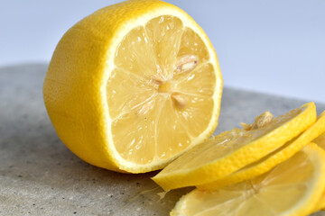 A juicy lemon, cut into slices, lies on a plate.