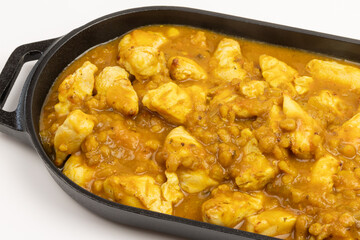 poulet cuisiné avec une sauce au curry, lentilles et citrouille, isolé sur un fond blanc