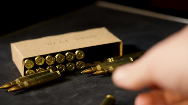 Sepia tones of several rounds of 5.56 box ammo.