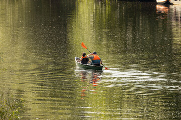 Father and daughter canoeing on calm river in UK for a summertime adventure