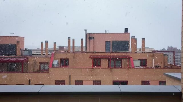 Nevando sobre las azoteas de edificios modernos. Nieve cayendo en una tormenta de primavera en Madrid, Espa&ntilde;a. 27 03 2020.