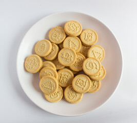 round cookies with various designs on them, including Christmas themed symbols like trees, snowmen, and other festive characters. vanilla or butter flavored sandwich cookies.