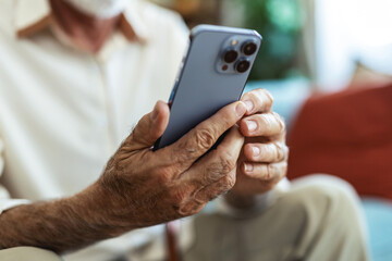 Senior man, phone and typing on sofa for web surfing with retirement, chess game and connection in home. Elderly person, mobile and relax with ebook app, online puzzle and internet scroll in lounge.