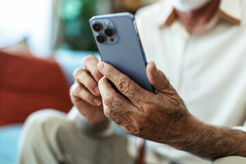 Happy senior man, phone and social media on sofa in relax for communication or networking at home. Mature men smile on mobile smartphone for online chatting, texting or search at house, close up.