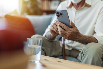 Home, senior man on sofa and smartphone with typing, internet and message for contact, texting and relax. Mature person, apartment and elderly guy on couch, cellphone and mobile user with network.