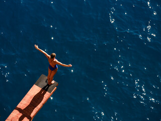 a female professional swimmer about to dive into the sea
