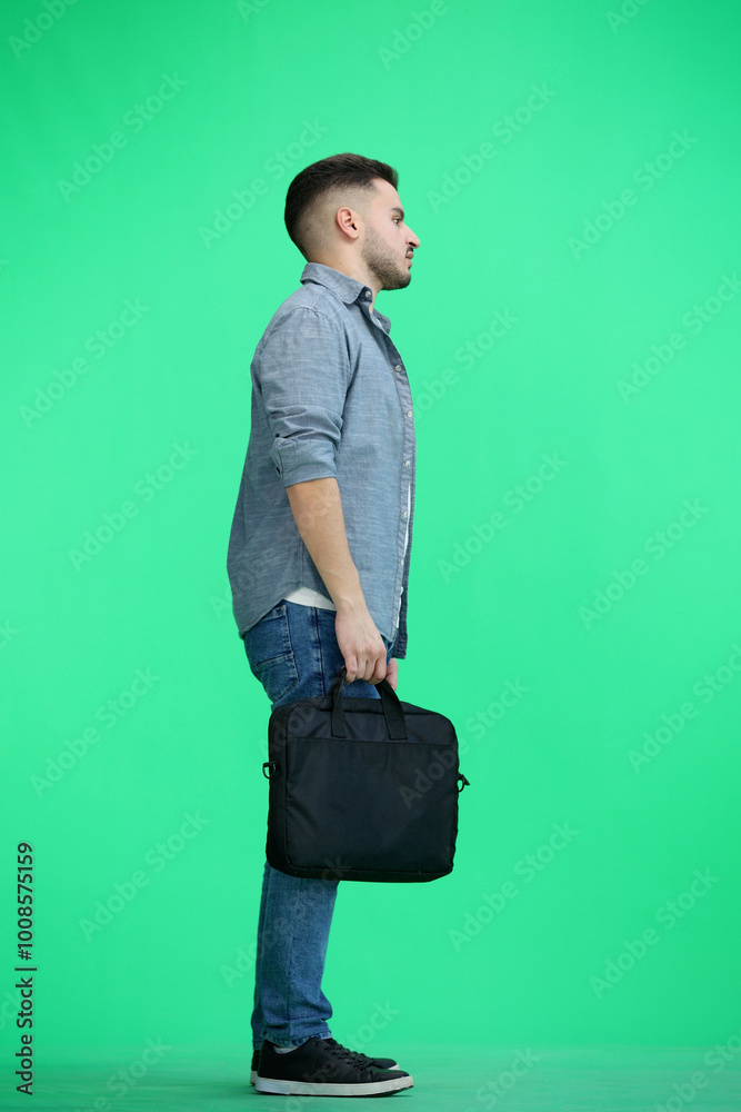 Wall mural A man, full-length, on a green background, with a briefcase