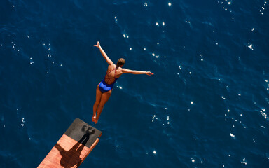 a female professional swimmer about to dive into the sea