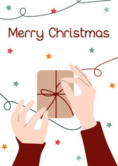 Holiday wrapping. Close up of hands tying a bow on gift with Christmas background. Greeting card with Christmas gift wrapping. Xmas card