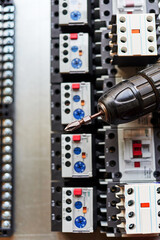 electric screwdriver on the background of magnetic starters