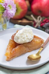 Slice of apple Tart Tartin with whipped cream, french upside down cake, vertical
