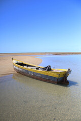 Fototapeta premium Wooden Boat Stranded on a Sandy Beach
