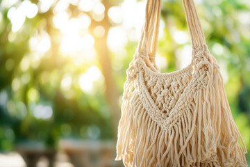 Fototapeta premium Beautiful handmade macrame bag hanging outdoors, illuminated by the warm glow of the sun