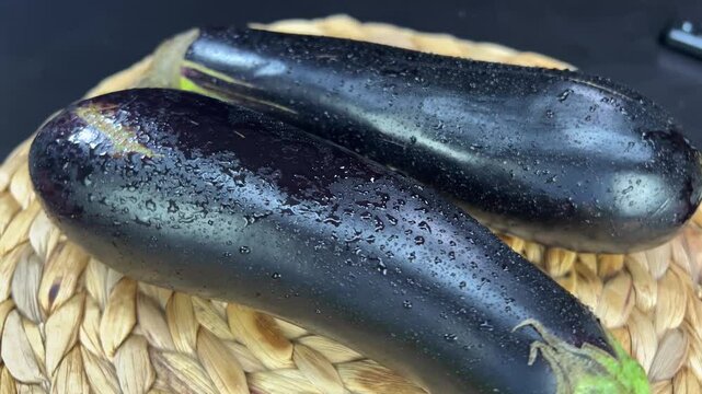 Plate rotating with fresh colorful two ripe eggplants