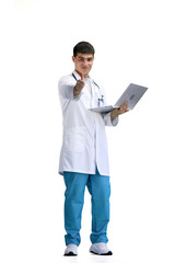 The doctor, in full height, on a white background, uses a laptop