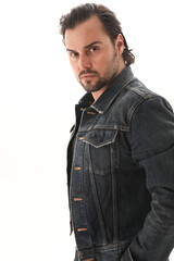 Portrait of bearded handsome man wearing denim jacket and looking at the camera. Vertical.