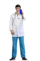 The doctor, in full height, on a white background, shows a phone