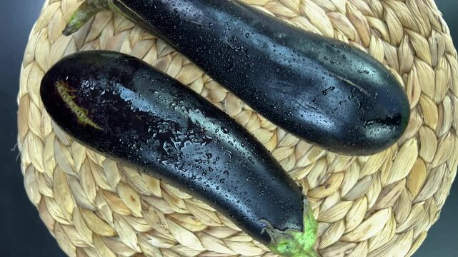 Plate rotating with fresh colorful two ripe eggplants