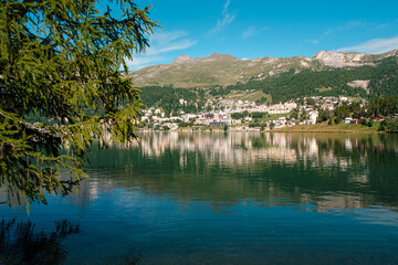 Scenic view on the St. Moritz mountain lake with the alpine resort on the other side on a bright summer day. Canton Grisons, Switzerland