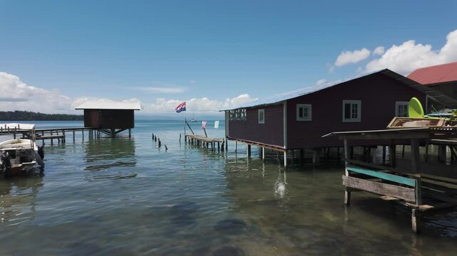 Pan across homes on stilted docks of Bastimentos Island's coastline in Bocas del Toro, Panama