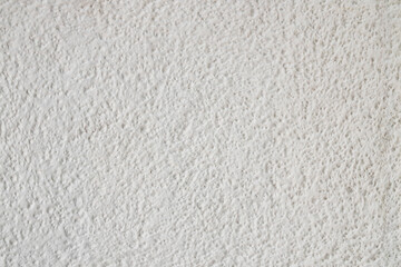 Textured concrete wall background of white painted concrete with small bumps and indentations