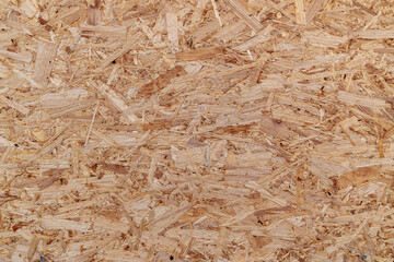 OSB board (Oriented Strand Board), showing overlapping wood fiber texture and light brown color