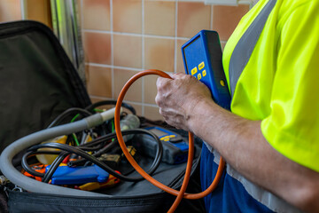 Gas Service Engineer wearing yellow high viz vest holding digital differential manometer pressure...