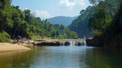 Obraz premium The peaceful waters of Sai Yok Noi Waterfall, with tourists enjoying the natural surroundings.