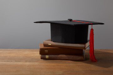 A graduation cap rests upon a stack of books, symbolizing achievement and the pursuit of knowledge...