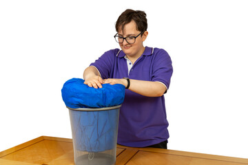Young student stuffs blue sleeping bag into waster paper trash can bin ready for going back to college university, isolated on white background