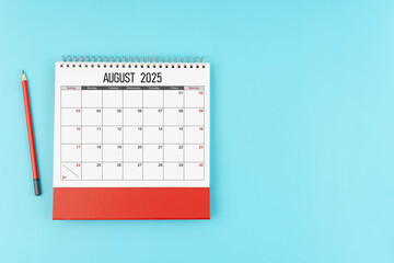 August desk calendar for 2025 year with pencil on blue background, Position with copy space.