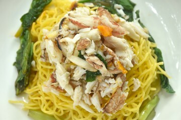 Chinese egg yellow noodles topping crab meat on plate