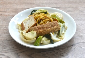fried yakisoba noodles and cabbage with carrot topping tofu vegetarian food on plate