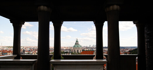 Panorama of Prague, seen through the columns of an ancient loggia located on Petr&iacute;n Hill. Banner shape.