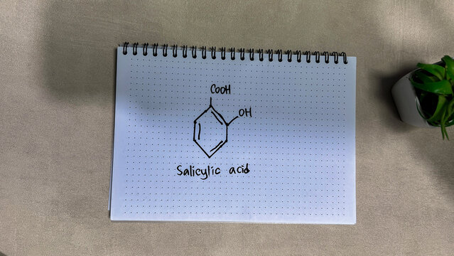 Concept of chemical molecular formule hormone Salicylic Acid write on book isolated on Wooden Table.