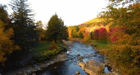 ll colors on the river, autumn trees reflected in water, woodstock, vermont. usa