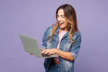 Young IT woman she wear denim jacket violet top casual clothes hold use work on laptop pc computer...
