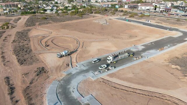 An aerial drone shot capturing a lorry at work on the new road construction site in Playa Flamenca, highlighting urban development and infrastructure expansion
