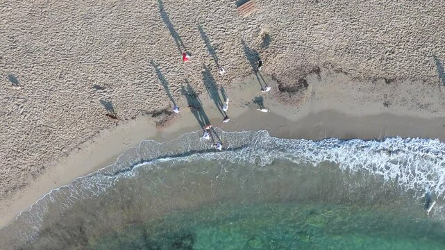 Top-down drone video of dogs and their owners enjoying a sunny day at the dog-friendly Playa Flamenca beach along the Costa Blanca in Spain