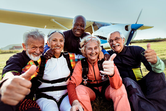 Senior group of diverse skydivers taking selfie after jump