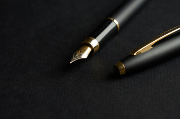 Fountain Pen on a black background with copy space. Golden ink pen, close-up