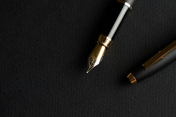 Fountain Pen on a black background with copy space. Golden ink pen, close-up