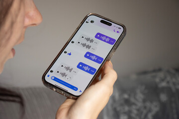 A European woman records an audio message. Sending a message via messenger. Gadget close-up. Telephone communication. Copy space