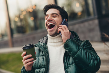 Photo of positive glad cheerful handsome man listening news laughing pastime autumn weather outdoors
