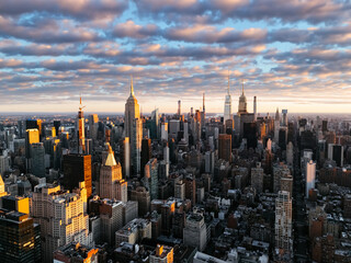 An aerial photo of Manhattan's upper downtown from above during the sunrise clouds in the...