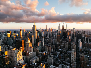 An aerial photo of Manhattan's upper downtown from above during the sunrise clouds in the background. New York, USA