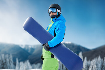 snowboarder and snowboard, portrait on a background of mountains